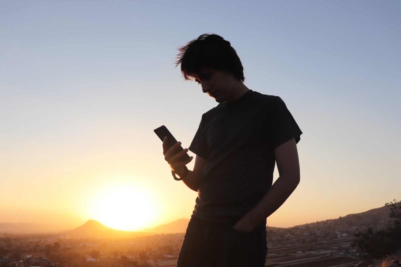 man in black t-shirt holding smartphone